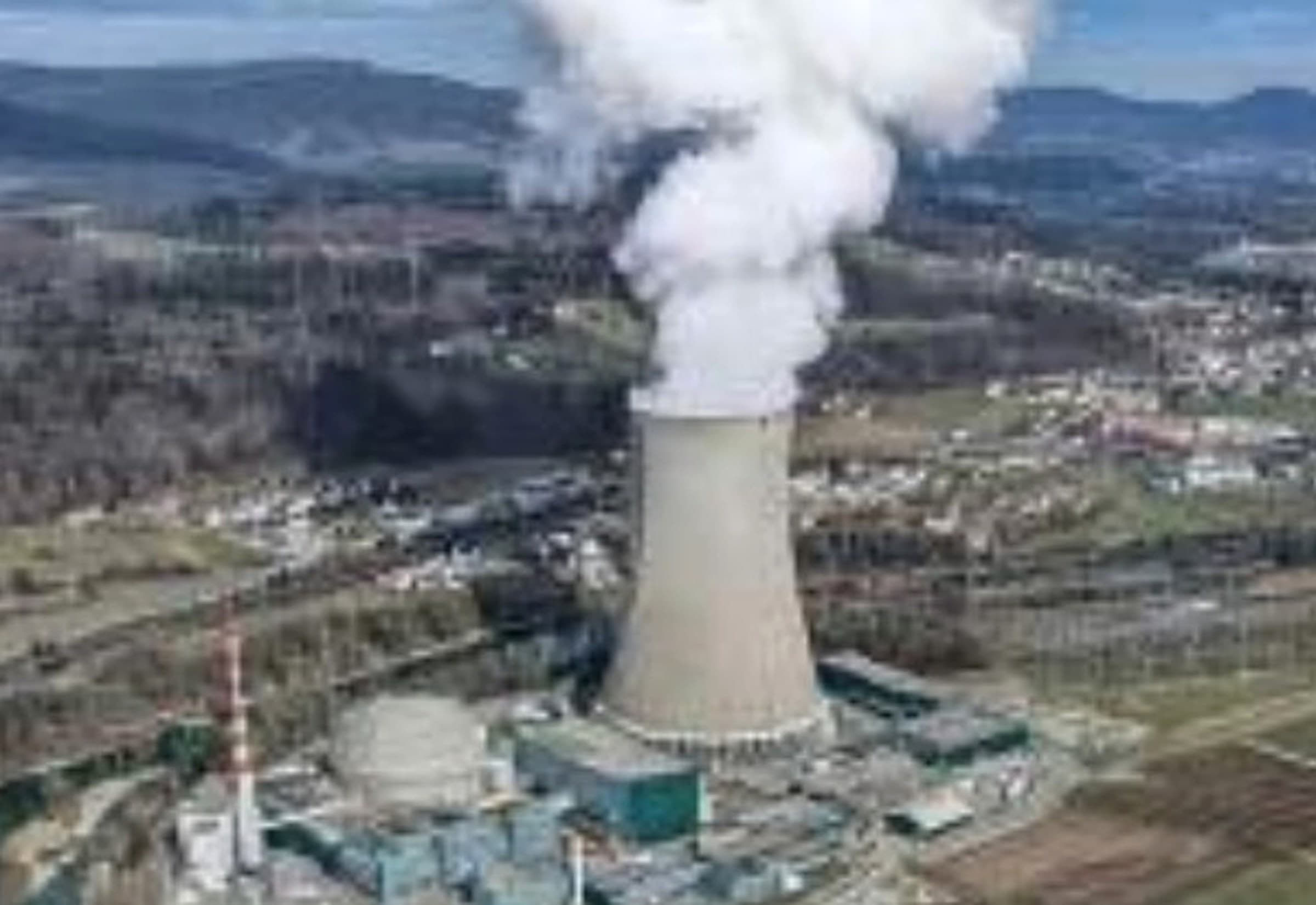Drone equipped with megaphone module operating over an urban skyline.